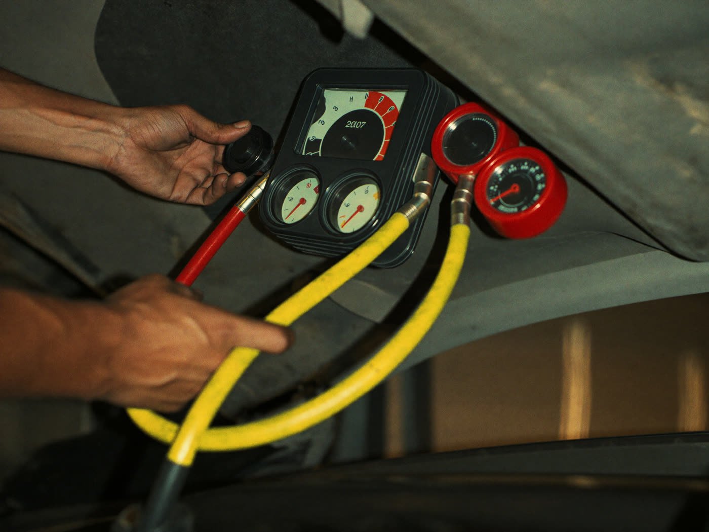Manómetros conectados a un auto para carga de aire acondicionado
