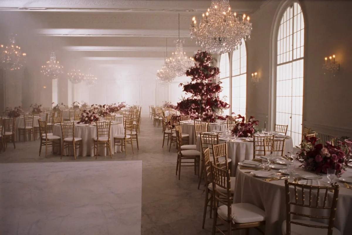 Salón principal de Villa Aurelia con mesas redondas, sillas doradas y arañas de cristal